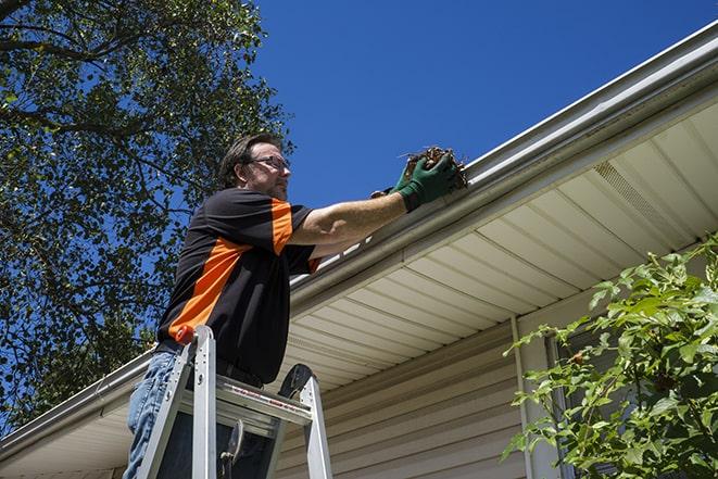 two workers fixing a gutter on a residential house in Anderson SC