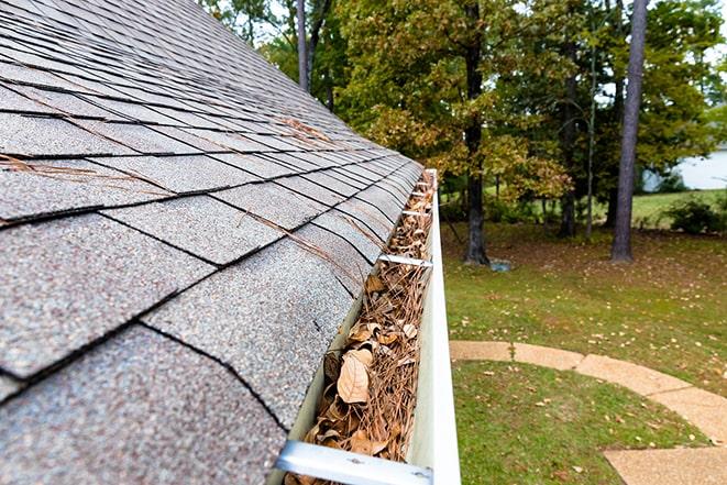 removing leaves and twigs from a residential gutter